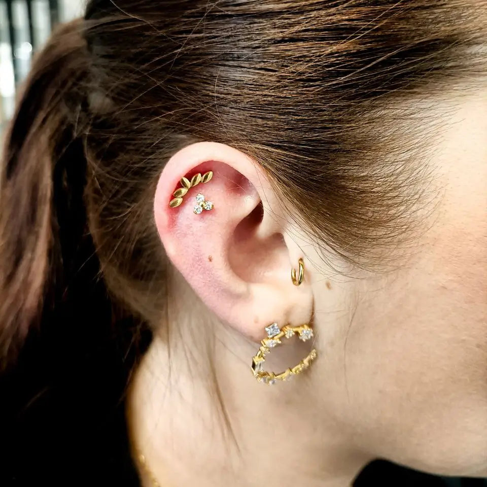 Piercing en titane finition pvd or avec pierre de zircon porté par une cliente Nåald