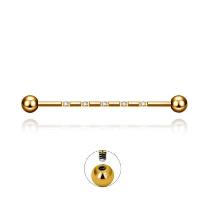 Barre piercing industriel Isidora en titane doré avec cristaux de zirconium, fermeture en pas de vis externe.