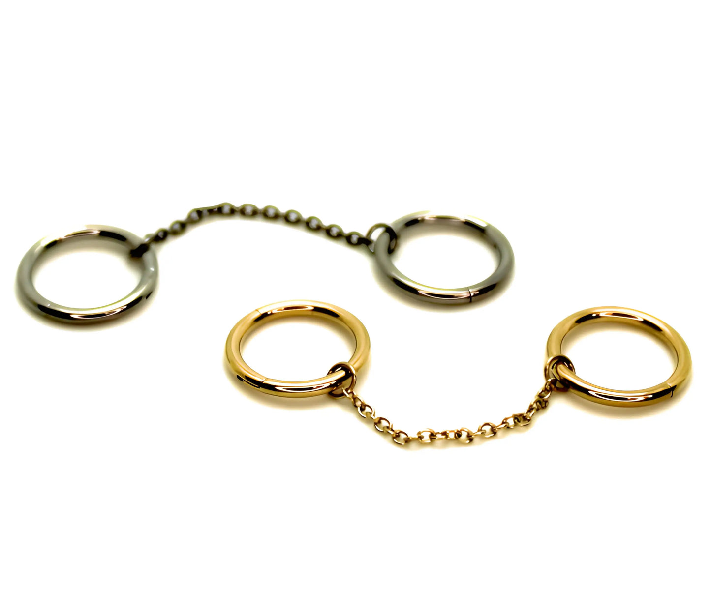 Présentation de 2 bijoux de piercing en titane. L'un en finition PVD or, l'autre de couleur argenté, constitués de 2 anneaux chacun reliés entre eux apr une chainette de 2 cm