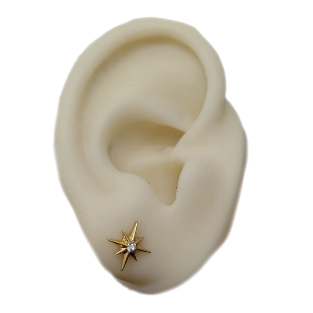Piercing lobe Staros porté sur oreille avec motif étoile doré et zirconium central