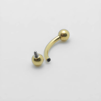 Présentation d'un bijou de piercing en titane banane barbell courbe finition PVD or avec billes simples et vissage interne